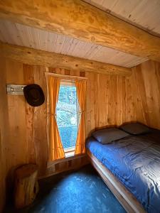a bed in a room with a window at Gluba Lavvo in Harkmark