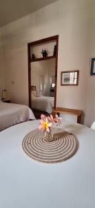 a vase of flowers sitting on top of a bed at Monoambiente en Puerto Nuevo in Concepción del Uruguay +1 photo