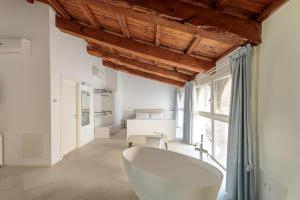 a bathroom with a white tub and a bedroom at Palazzo Simonetti in Ascoli Piceno