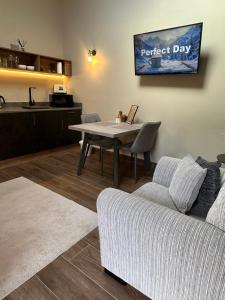 a living room with a table and a couch at Oak field Cottages Belfast open plan studio stunning & tranquil in Dunmurry