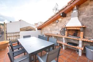 a table and chairs on a balcony with a fireplace at Cuencaloft Casa Rural Eloy in Carboneras de Guadazaón +48 photos