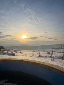 a view of a beach with the sun setting at Cabana Popesti in Popeşti +7 photos