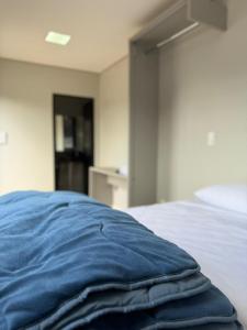 a blue blanket laying on top of a bed at Arena Bitz in Pato Branco