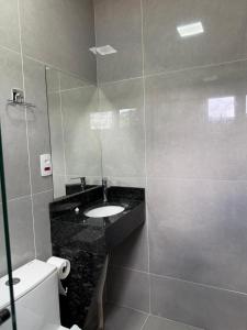 a bathroom with a sink and a mirror and a toilet at Arena Bitz in Pato Branco