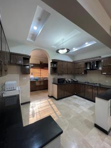 a large kitchen with wooden cabinets and a white refrigerator at Urban Villa in Islamabad