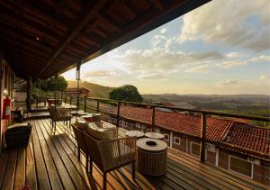 a wooden deck with chairs and tables on a balcony at Pousada do Xerife in Caconde