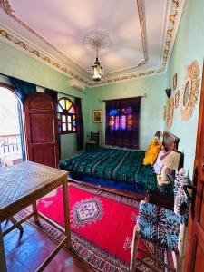 a bedroom with a bed and a table in it at Riad Soleil du Monde in Zagora