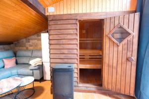 a small wooden house with a couch and a table at Cuencaloft Casa Rural Eloy in Carboneras de Guadazaón