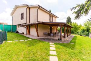 a house with a covered patio in the yard at house Al Cascinale in San Severino Marche