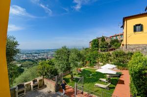 a woman walking down a hill next to a building at Holiday Home Il Borgo Degli Agrumi in Uzzano