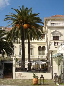 a palm tree in front of a white building at Villa Imperiale Hotel in Spotorno