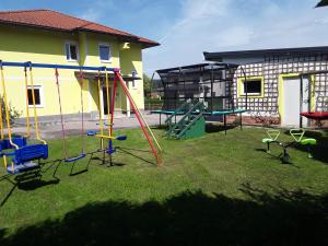 a yard with a playground with swings and a building at Apartments Steger in Faak am See