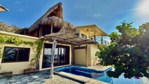 a villa with a swimming pool in front of a house at Casa Obe in Yolina