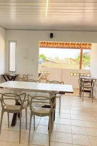 a dining room with a large table and chairs at Pousada Beach Claudia in Maragogi