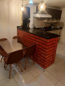 a kitchen with a table and chairs next to a brick wall at à 5 minutos do Parque do Povo in Campina Grande