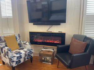 a living room with two chairs and a fireplace at Romantic Studio Apt in Historic Downtown Savannah in Savannah