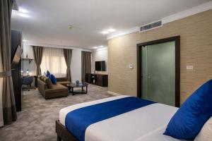 a hotel room with a bed and a living room at Al Basem Hotel in Amman