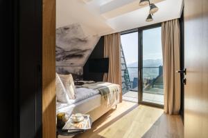 a hotel room with a bed and a large window at Salamandra Luxury Villas with Jacuzzi by BQQK in Kościelisko +88 photos