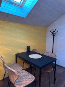 a dining room table with chairs and a window at Apartmány U GUNÁRA Vyhne - Apartmán Akácia in Vyhne