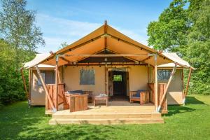 a tent with a wooden deck in a yard at Lodges en pleine nature in Riez