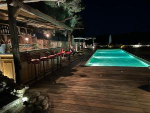 a swimming pool at night with chairs and a bar at Lodges en pleine nature in Riez