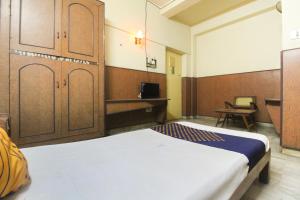 a bedroom with a bed and wooden cabinets at Hotel O Maruthi in Salem +15 photos