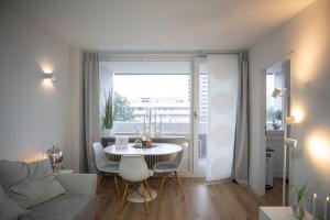 a living room with a table and a couch at Cozy apartment with pool I U-Bahn in Munich