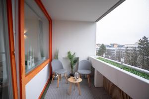 an apartment balcony with two chairs and a window at Cozy apartment with pool I U-Bahn in Munich