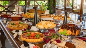 a buffet with many different types of cakes and pies at Pousada Bicho Preguiça in Pipa