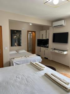 a bedroom with three beds and a flat screen tv at "HOLIDAY" apartments & rooms in Ulcinj