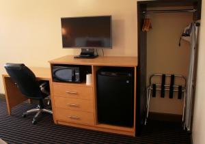a desk with a tv and a computer on top of it at Regency Inn in Vallejo