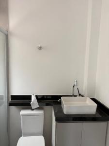 a bathroom with a white sink and a toilet at Kit Gonzaga Santos in Santos
