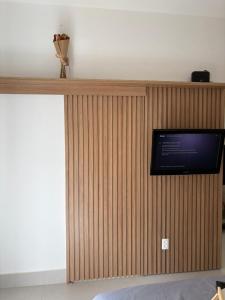 a wall with a tv on top of a wooden wall at Kit Gonzaga Santos in Santos