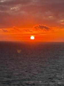 an orange sunset over the ocean at Kit Gonzaga Santos in Santos