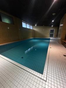 a large swimming pool with a blue tile floor at Cozy apartment with pool I U-Bahn in Munich