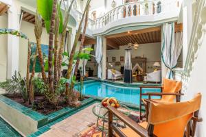 a pool in a house with trees and chairs at Riad Habouba in Marrakesh