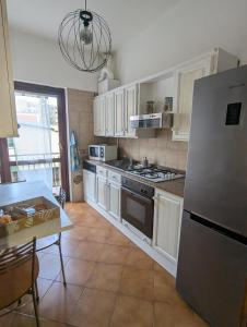 a kitchen with white cabinets and a stainless steel refrigerator at Casafiorella in Monza