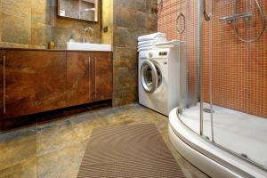 a bathroom with a washing machine and a sink at BridgeStoneLuxApart Free Parking in Riga +46 photos
