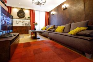 a living room with a couch and a television at BridgeStoneLuxApart Free Parking in Riga