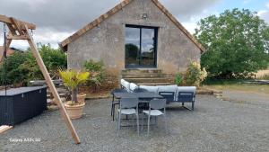 a table and chairs in front of a house at Maison de 50m2 à la campagne in Pirmil