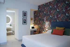 a bedroom with a white bed and a floral wallpaper at Casa Diez in Estepona