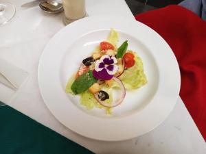 a white plate with a salad on a table at Linkgreen Homestay Lombok in Tetebatu
