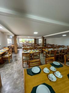 a dining room with wooden tables and chairs at Pousada Arco Iris Fortaleza in Fortaleza