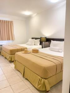 two beds in a hotel room with two beds at Hotel Kariña Punta de Mata in Punta de Mata