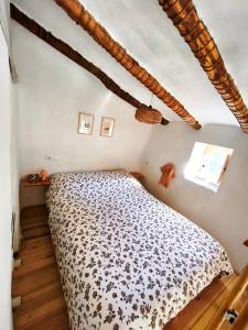 a bedroom with a bed with a black and white comforter at Casa Rural La Encalá in Ayna