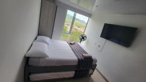 a small bedroom with a bed and a window at Espectacular apartamento en Guaduas in Guaduas +36 photos