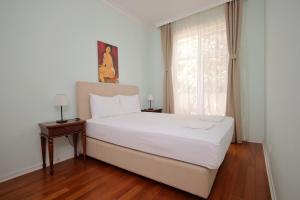 a bedroom with a white bed and a window at Apartman A4 - Dvorac Belimarkovic in Vrnjačka Banja
