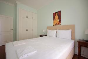 a bedroom with a large white bed in a room at Apartman A4 - Dvorac Belimarkovic in Vrnjačka Banja