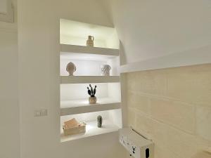a room with white shelves with vases on them at La Casa di Ninetta - Boutique Stay in Monopoli