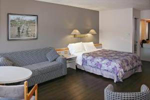 Habitación de hotel con cama y sofá en Motel à la Brunante, en Sainte-Anne-des-Monts